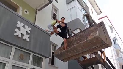 Ağır hasarlı binada mahsur kalan çocuk kepçe ile kurtarıldı